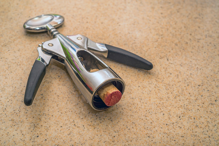 Modern stylish corkscrew and wine cork on tableの写真素材