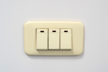 Beige rocker light switch with three buttonsの写真素材