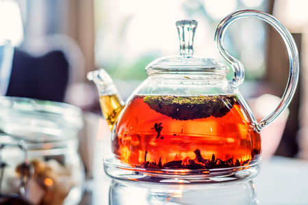 Modern glassy teapot with fresh teaの写真素材