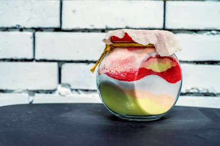 Colored sand poured in layers in a bottle