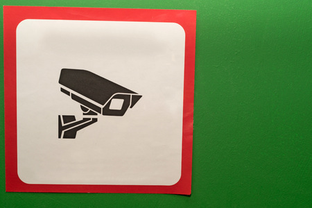 Video surveillance sign indoors on green wallの写真素材