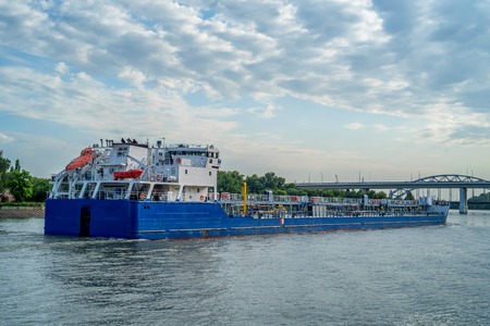 Oil tanker on river on sunny dayの写真素材