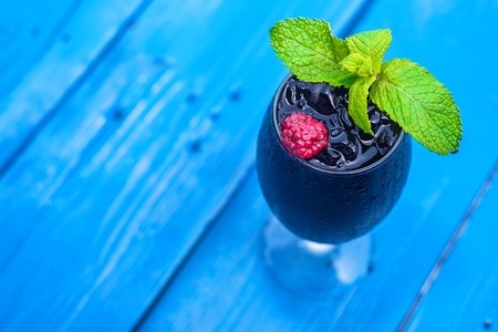 Dark restaurant cocktail with mint and raspberryの写真素材