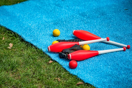 Juggling clubs and balls on lie blue mat close-upの写真素材