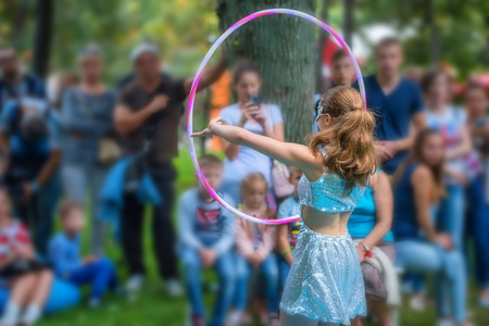 Girl in beautiful dress performs with hula hoopsの写真素材