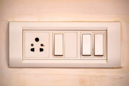 Beige rocker light switch with three buttons