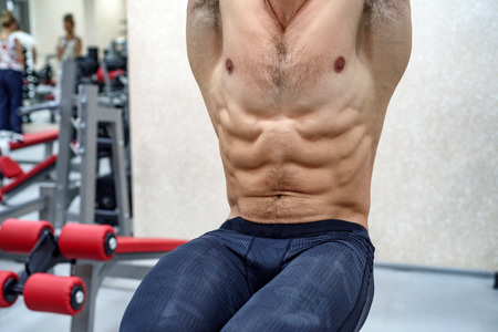Handsome muscular man doing abs exercise
