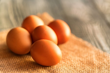 Fresh farm brown eggs on rustic background