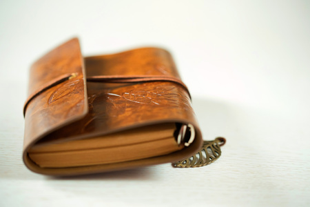 Old leather book on wood backgroundの写真素材