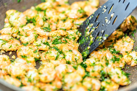 Close up of prawns fried in a frying pan with garlic butter and herbs. Traditional Thai cuisine. Seafood cookingの写真素材
