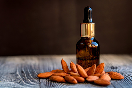 Sweet almond oil in glass jar and kernelsの写真素材