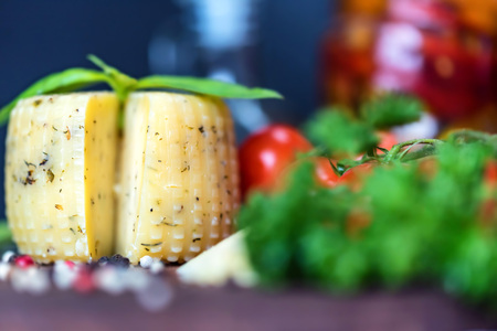 Rustic cheese with herbs, pepper and vegetablesの写真素材