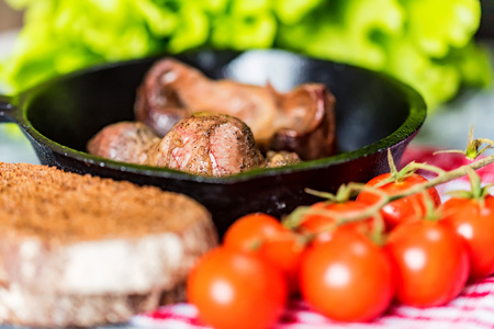 Tasty roasted chicken giblets in pan and rye breadの写真素材