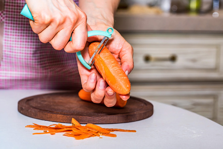Womans hand peel carrot closeの写真素材