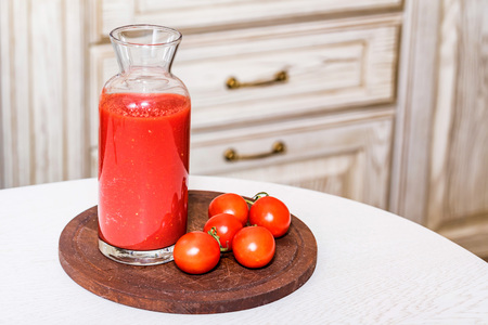 Glass bottle of tomato juice with fresh tomatoesの写真素材
