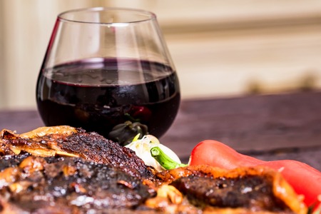 Beef steak with spices, vegetables and wine closeの写真素材