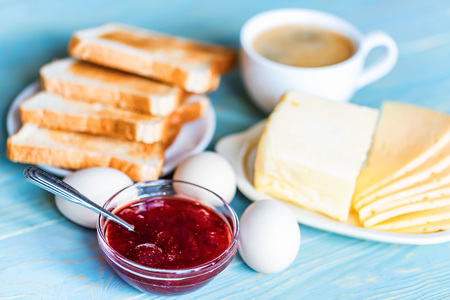Breakfast with coffee, eggs, toasts, cheese, jamの写真素材