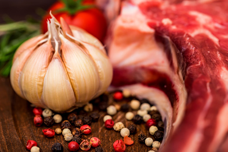 Raw beef steak with pepper, herbs and tomatoesの写真素材