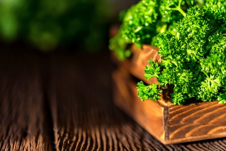 Parsley in wooden box on wooden background closeの写真素材