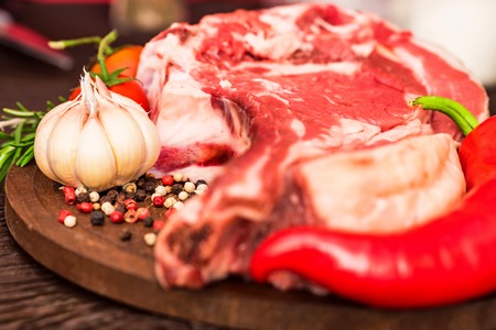 Raw beef steak with pepper, herbs and tomatoesの写真素材