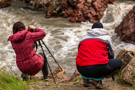 Outdoor photographers and autumn forest waterfallの写真素材