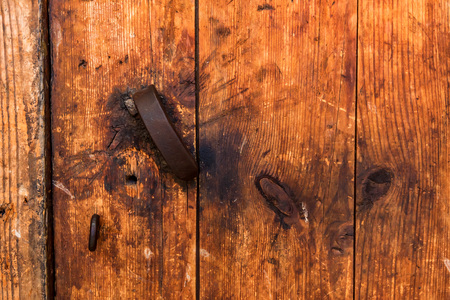 Old wooden door with broken metal handle closeの写真素材