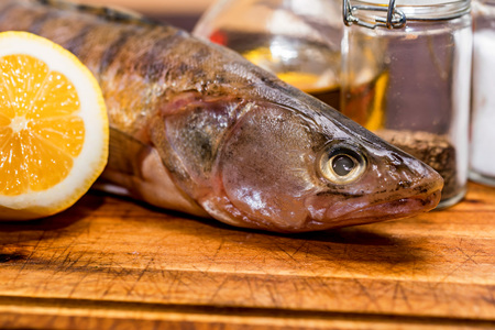 Close up fresh pike perch on kitchen table with lemon ready for cookingの写真素材