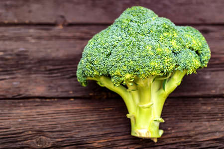 Green fresh broccoli on dark wooden surfaceの写真素材