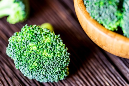 Fresh broccoli in wooden bowl on wooden surfaceの写真素材