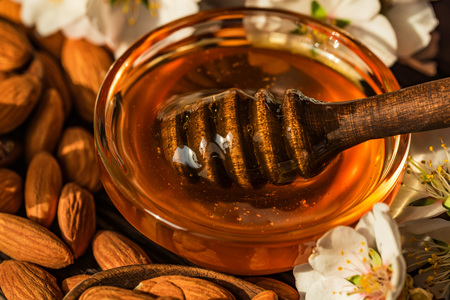 Almond honey, nuts and white flowers closeの写真素材