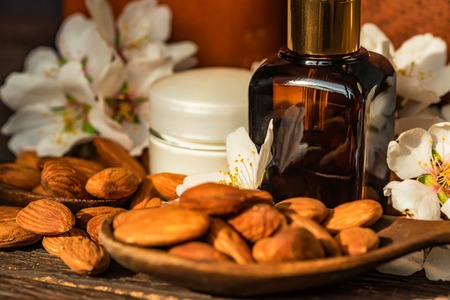 Almonds, oil, face cream and white flowersの写真素材