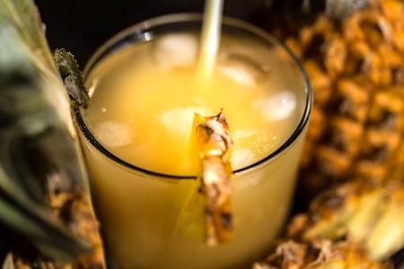 Pineapple juice and slice placed on a wooden tableの写真素材