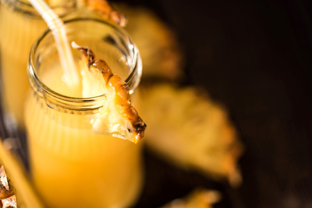 Pineapple juice and slice placed on a wooden table