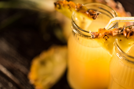 Pineapple juice and slice placed on a wooden tableの写真素材