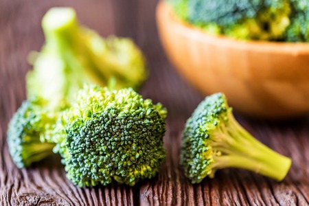 Fresh broccoli in wooden bowl on wooden surfaceの写真素材