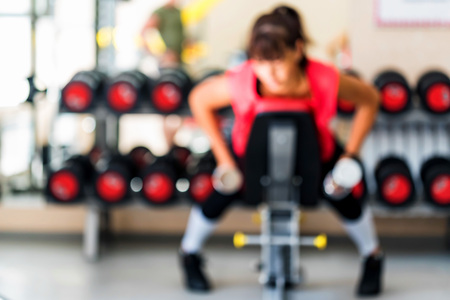 Young sporty woman trains in gym blurredの写真素材