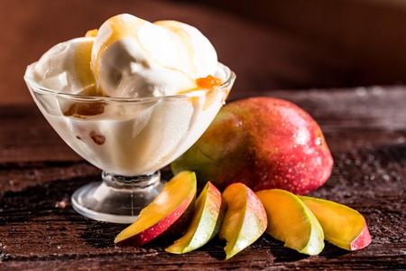 Caramel sauce ice cream and fresh mango fruitの写真素材