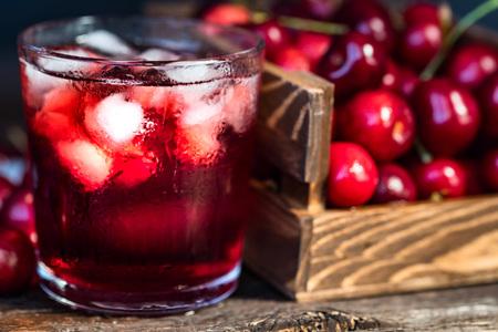 Fresh cherries in a wooden box, ice, cherry juiceの写真素材