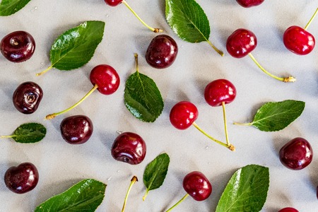 Sweet ripe cherries and leaves on white background