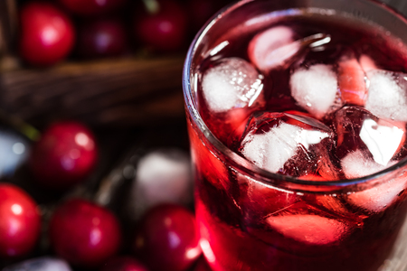 Fresh cherries in a wooden box, ice, cherry juiceの写真素材