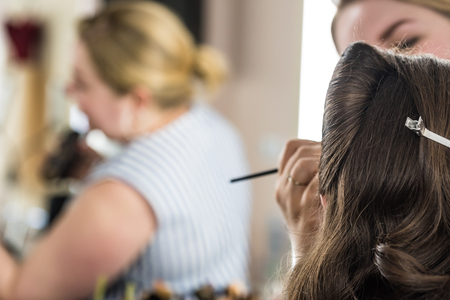 Back view make-up artist does make up for brideの写真素材