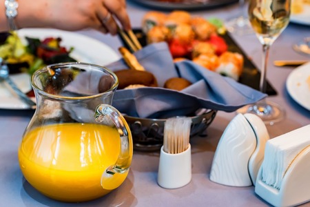 Orange juice in jug on restaurant tableの写真素材