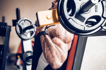 Athlete does deltoid exercises on hammer machineの写真素材