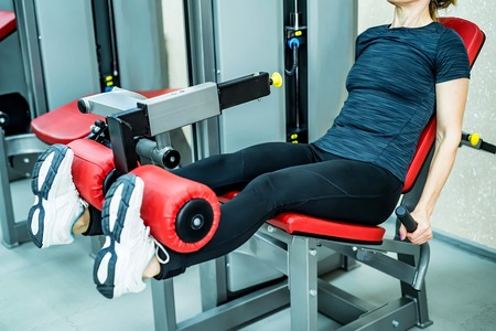 Young woman does leg exercises in gymの写真素材