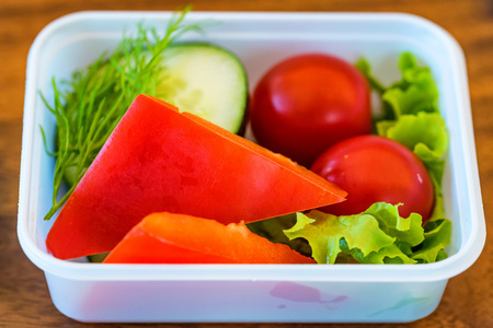 Plastic bowl with vegetables for airplane meal close