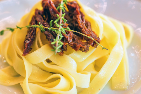 Tasty sun-dried tomato pasta on plate closeの写真素材