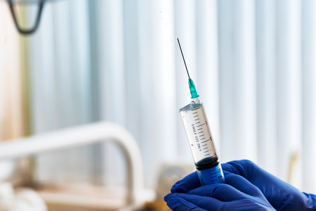 Hands in gloves hold syringe with injectionの写真素材