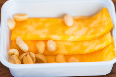 Plastic bowl with sliced cheese and nuts for airplane meal