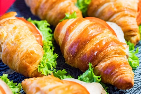 Close up fresh croissants with salad, ham and cheese on tableの写真素材