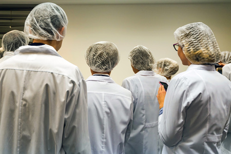 Food factory workers in uniform back viewの写真素材